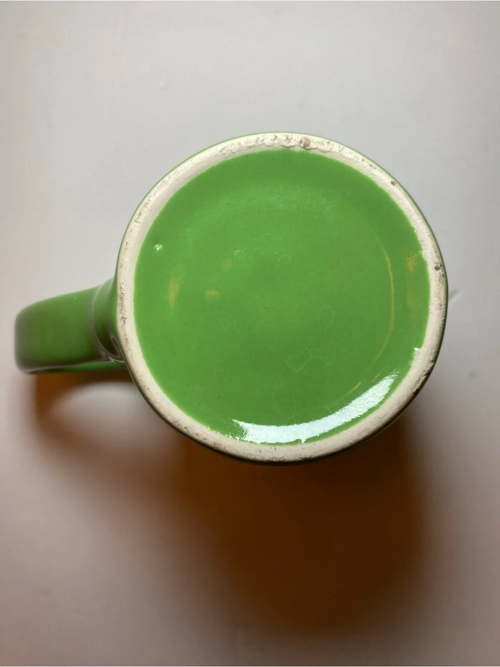 Urth Cafe ceramic coffee mug in green with white embossed logo
